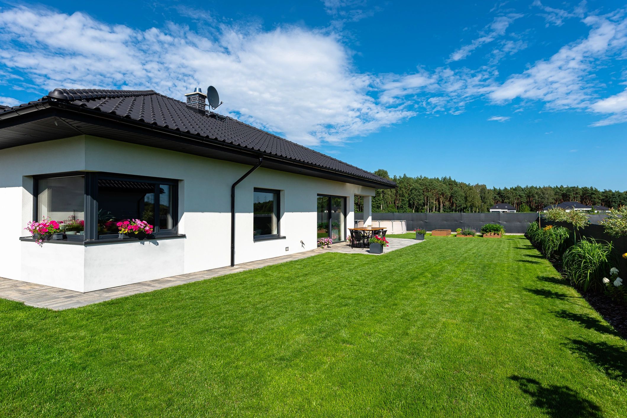 Residential home with landscaped yard and outdoor seating